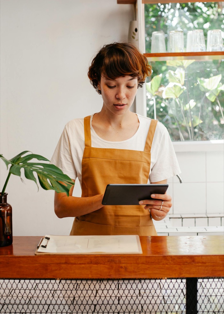 Restaurant team member reviewing service information on a tablet.