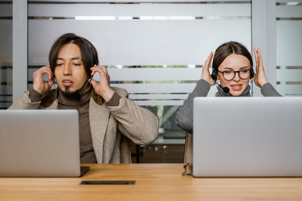 Customer support team members working with headsets and laptops.